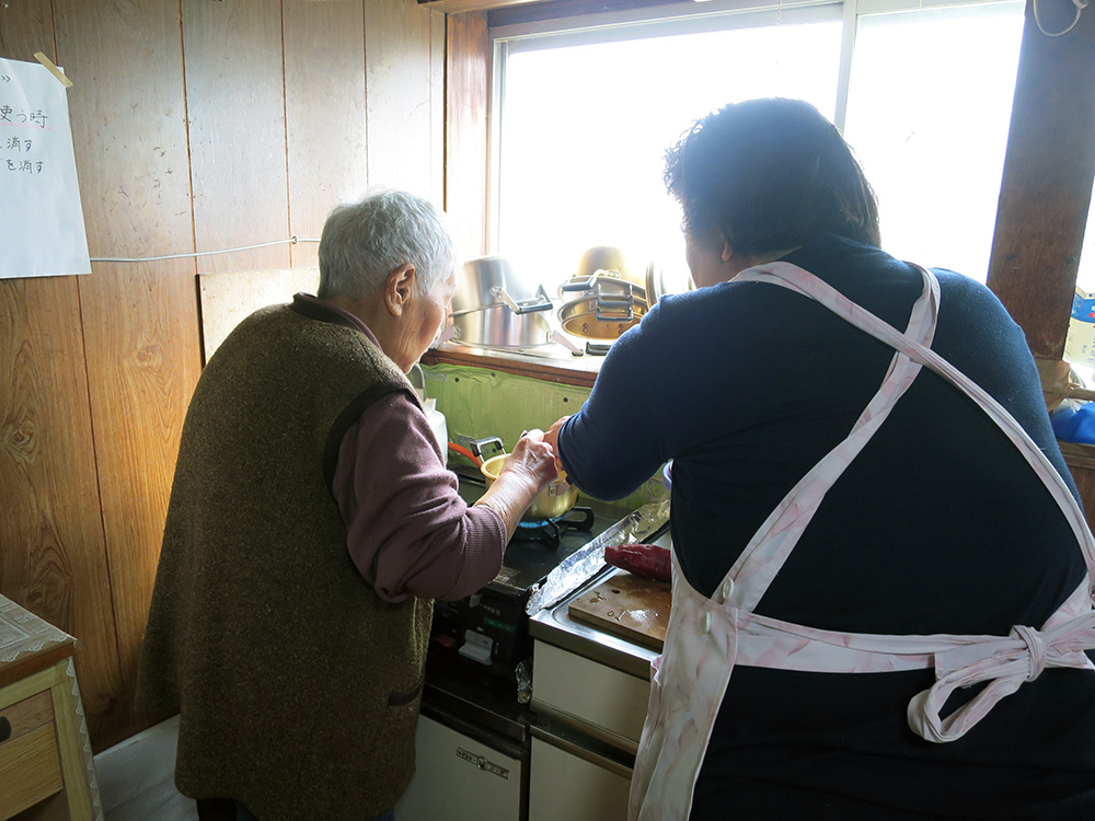 美土里荘訪問介護事業所：ホームヘルパーと一緒に調理をする利用者