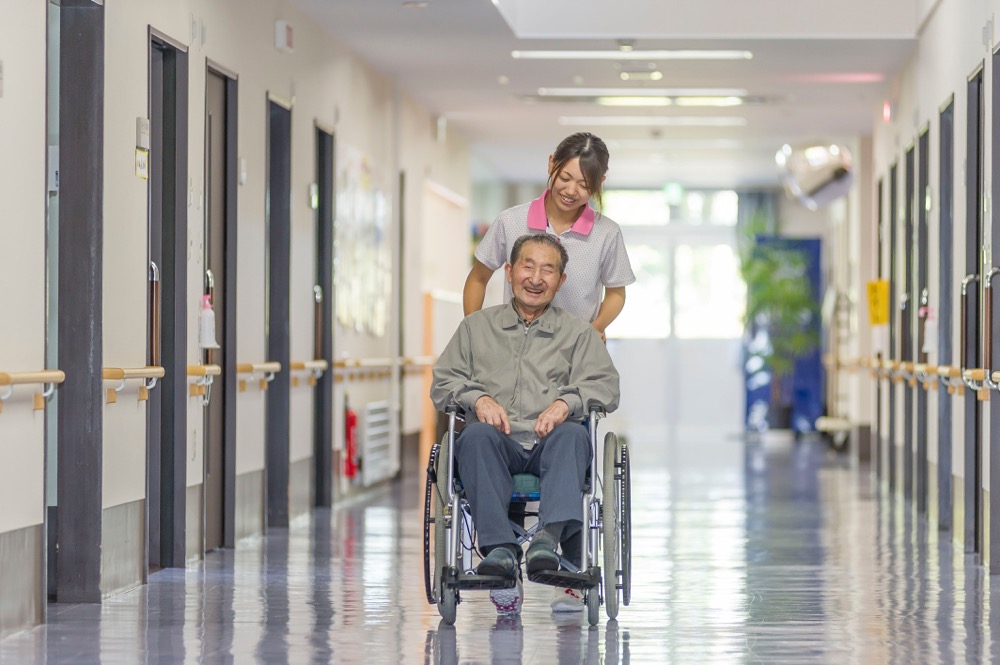 特別養護老人ホーム 美土里荘・介護員に車椅子を押してももらい、笑顔の入居者